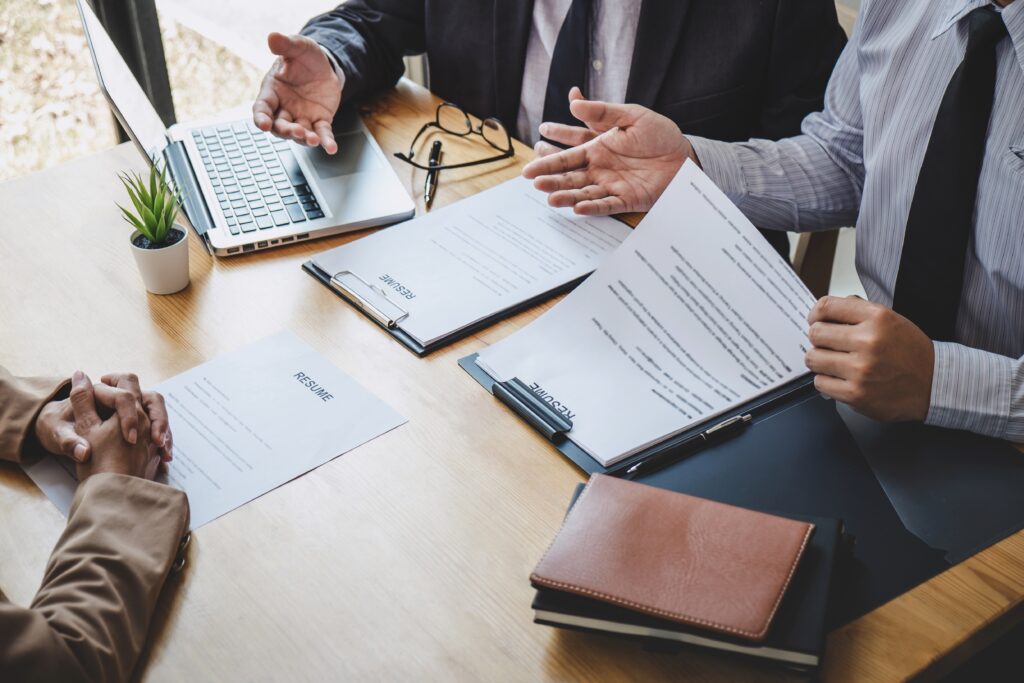 Two selection committee manager reading a resume during a job interview