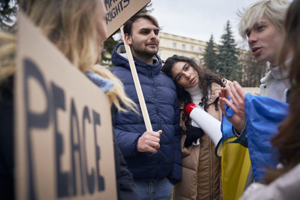Worried young caucasian people on manifestation against Ukrainian war outdoors